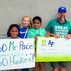 Encompass Heights Elementary School teacher smiles for a photo with students